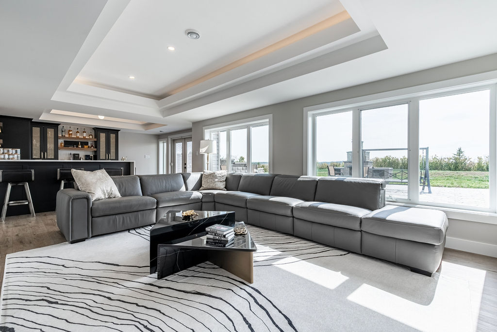 Walkout basement with dark cabinetry and gold accents, bright and spacious with floor to ceiling windows 