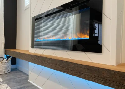 custom-built electric fireplace with accent lighting by Saskatoon basement developer by Axium Interiors