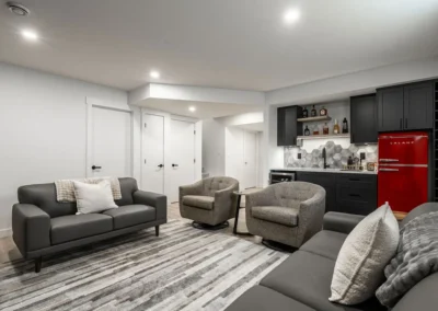 a modern basement with open layout, lounge area and sleek wet bar by Saskatoon basement developer Axium Interiors.