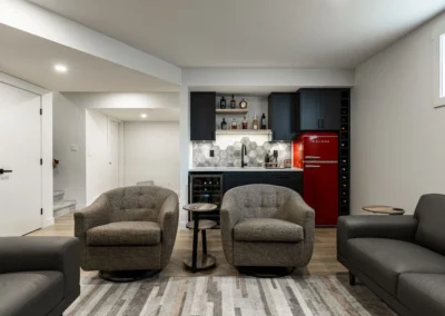 open basement layout with seating area and wet bar by Saskatoon basement developer Axium Interiors.