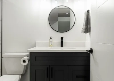 sleek basement bathroom with black vanity by Saskatoon basement developer Axium Interiors