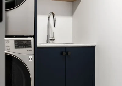 modern laundry space and minimalist sink setup by Saskatoon basement developer Axium Interiors